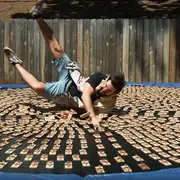 Dan jumping onto a trampoline covered in mousetraps